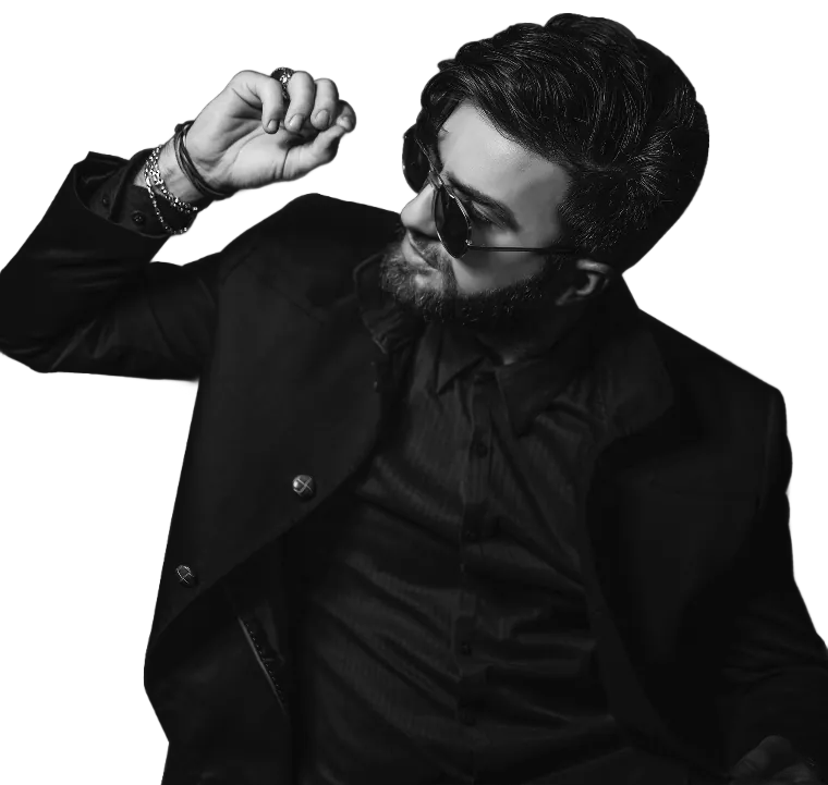 A seated man in sunglasses and an overcoat, one hand raised to his temple, in monochrome.